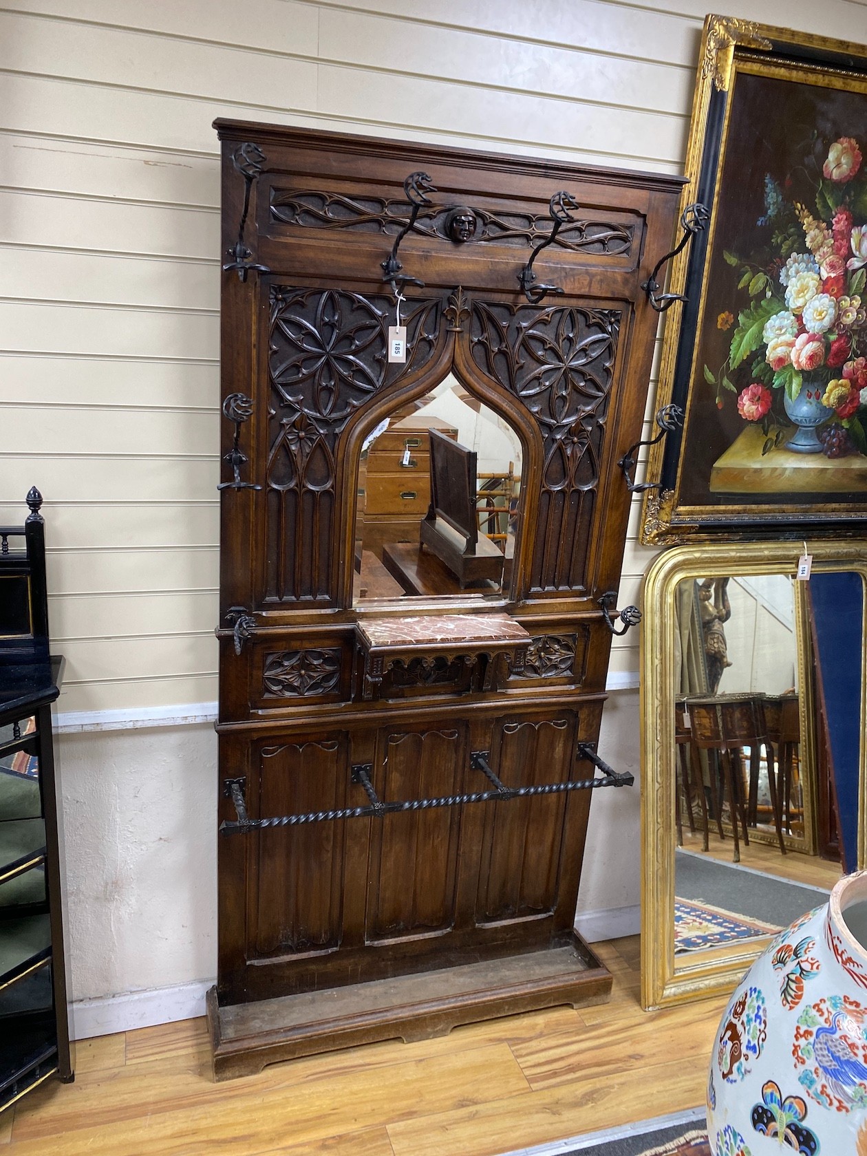 An early 20th century gothic revival wrought iron and rouge marble mounted carved mahogany hall stand, width 102cm, height 210cm